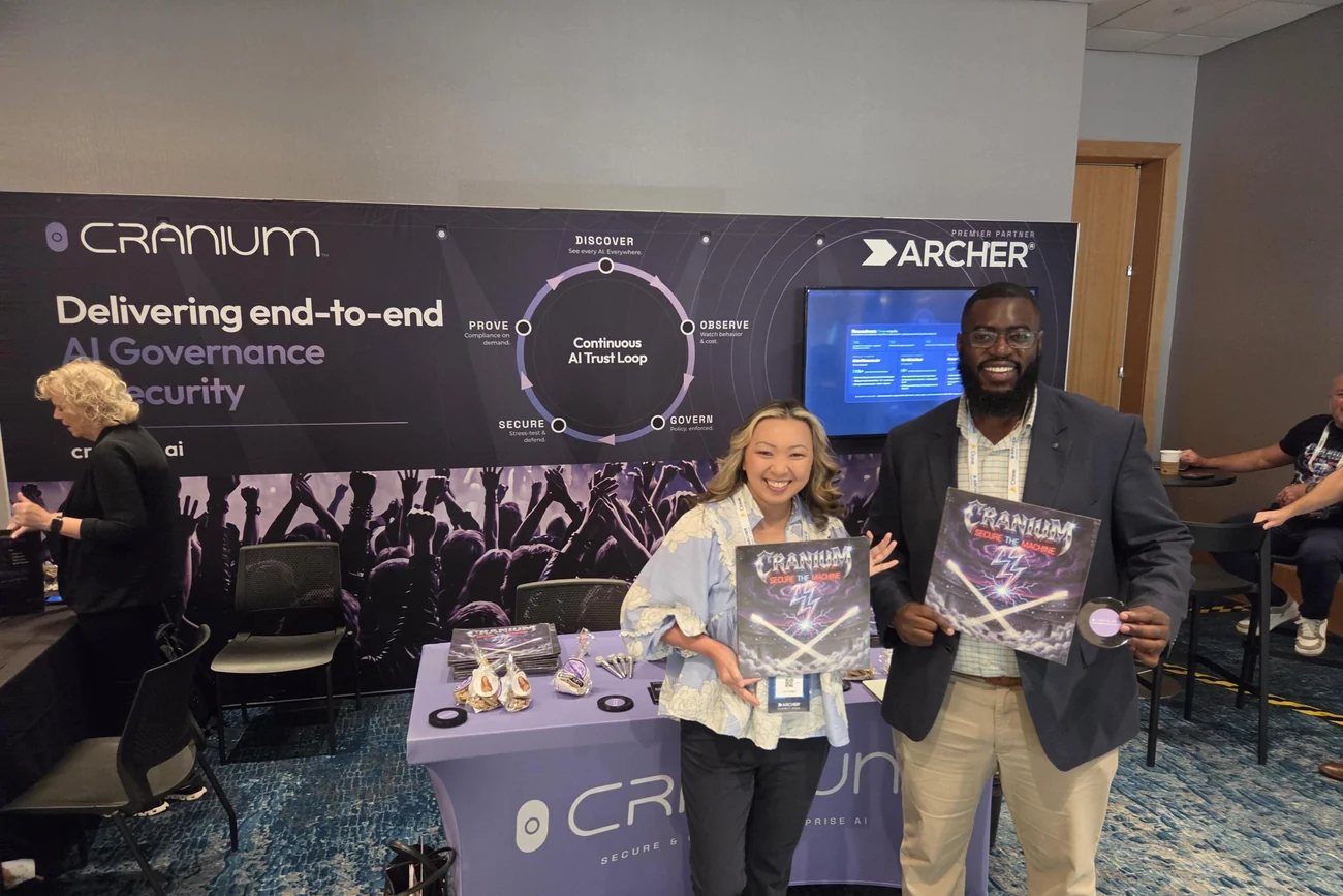 Two Archer Summit attendees holding limited-edition Craniacs &lsquo;Secure the Machine&rsquo; vinyl at the Cranium booth in Orlando