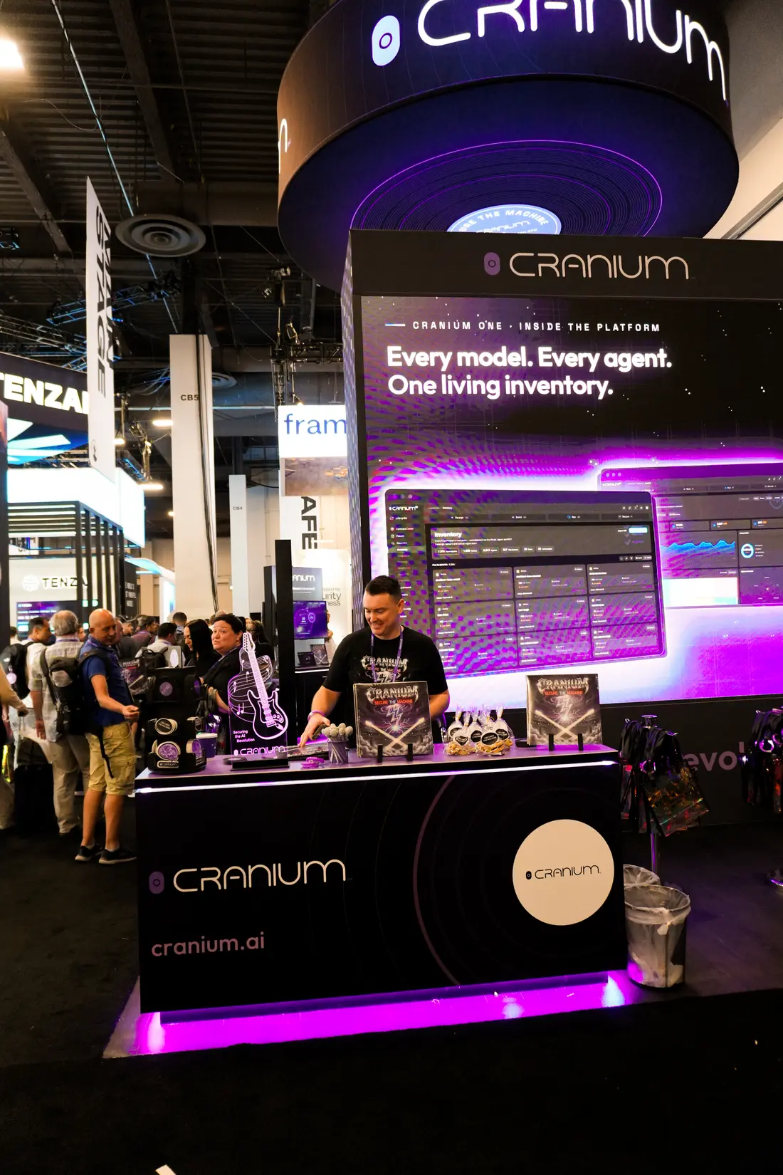 A live Cranium ONE demo running on the booth wall behind the counter