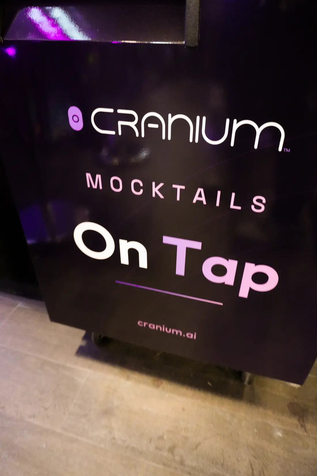 The &ldquo;Cranium Mocktails &mdash; On Tap&rdquo; sign at the booth bar