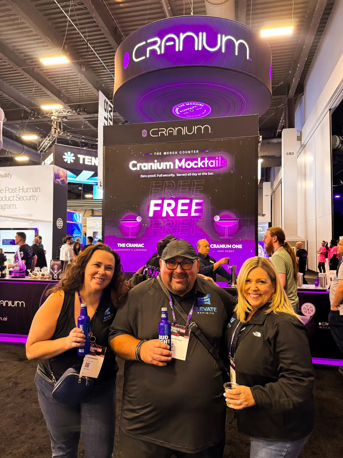 Attendees at the booth bar with the mocktails sign behind them